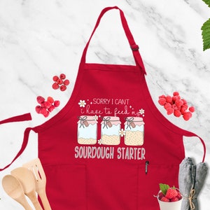 a red apron that says sorry i can't make it like a sourdou