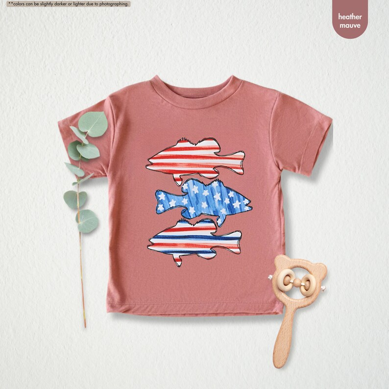 a t - shirt with a fish on it next to a pair of scissors