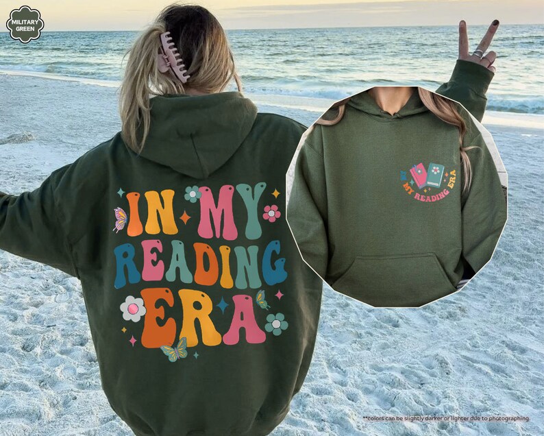a woman standing on a beach wearing a green hoodie