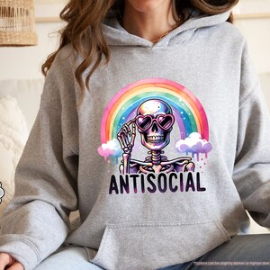 a woman sitting on a couch wearing a hoodie