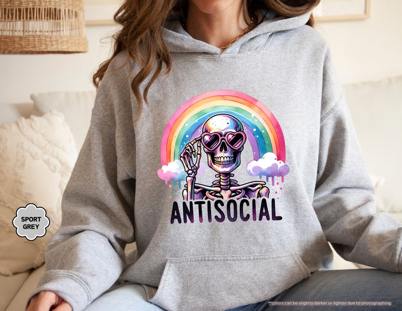 a woman sitting on a couch wearing a hoodie