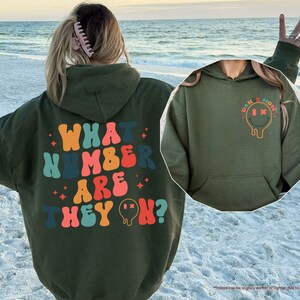 a woman wearing a green hoodie with what kind of are they? written on