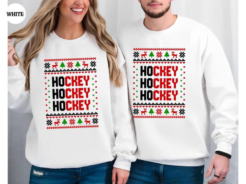 May include: White Christmas sweater with a red and black "HOCKEY" design. The sweater has a festive pattern with green trees and reindeer.