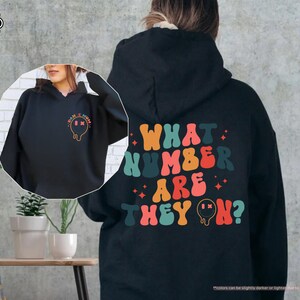 a woman wearing a black hoodie with what kind of are they? on it