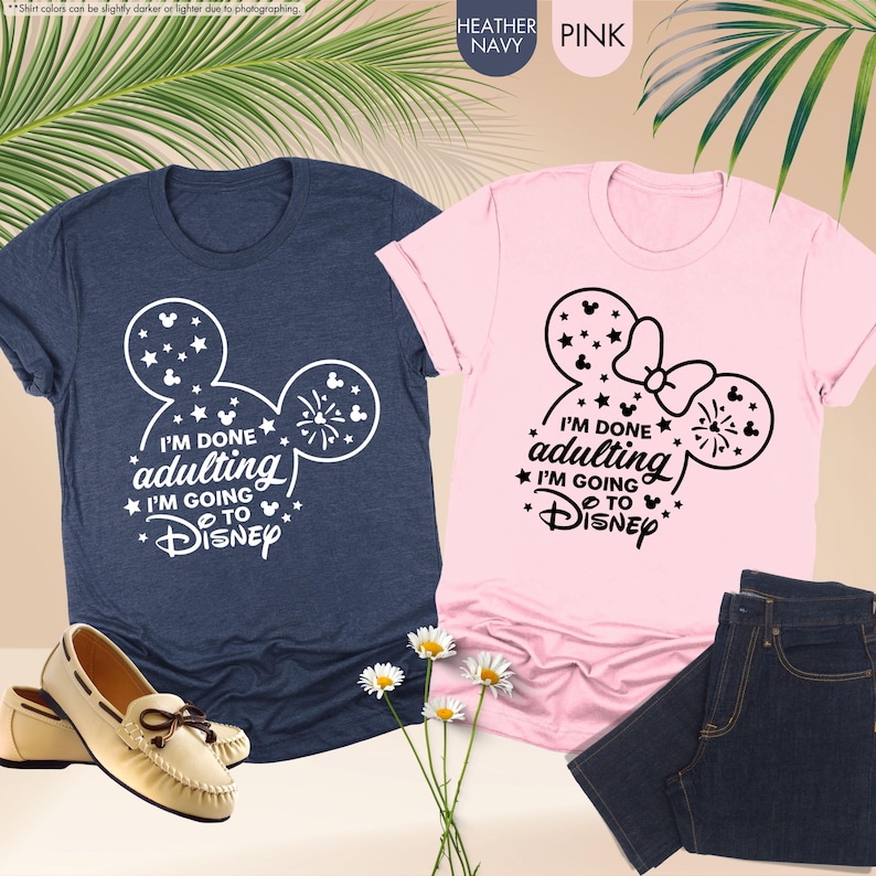 May include: Two t-shirts, one navy blue and one pink, with a white Mickey Mouse silhouette and the text "I'm done adulting I'm going to Disney".