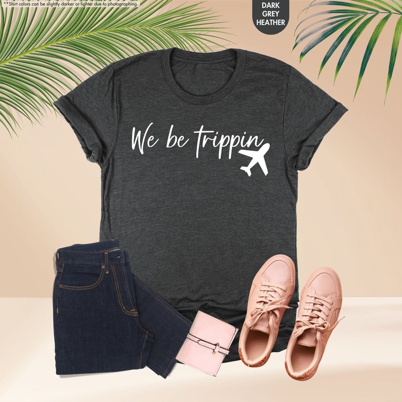 a t - shirt that says we are tripping next to a pair of jeans