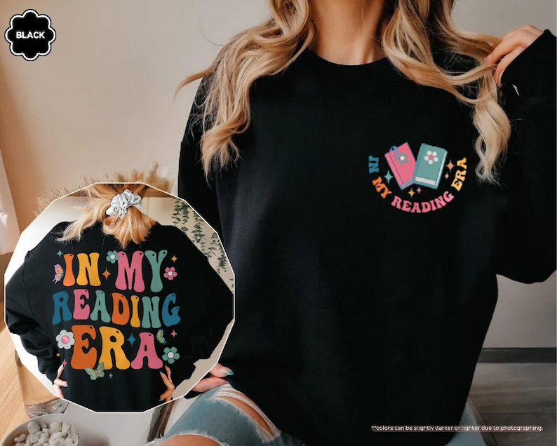 a woman wearing a black shirt with the words in my reading bra on it