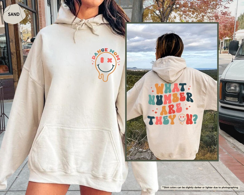 a woman wearing a white hoodie with the words what number are they? on