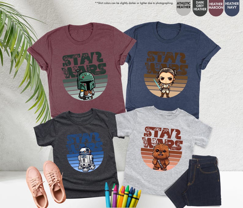 May include: Three t-shirts with different Star Wars characters in a retro style. The shirts are in dark heather, heather grey, and light grey. The characters are Boba Fett, Rey, and Chewbacca.
