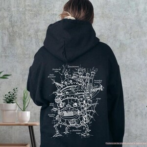 May include: Black hooded sweatshirt with a white graphic print of a detailed illustration of a flying machine with the text "Secondary propeller", "Discharge pipe", "Helix direction", "Stabilizer Legs", and "Gustohower" on the back.