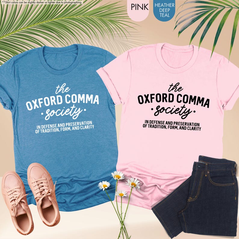 Op de afbeelding: Twee T-shirts met de tekst "the OXFORD COMMA Society. IN DEFENSE AND PRESERVATION OF TRADITION, FORM, AND CLARITY" erop gedrukt. E&eacute;n shirt is roze en de andere is blauw.