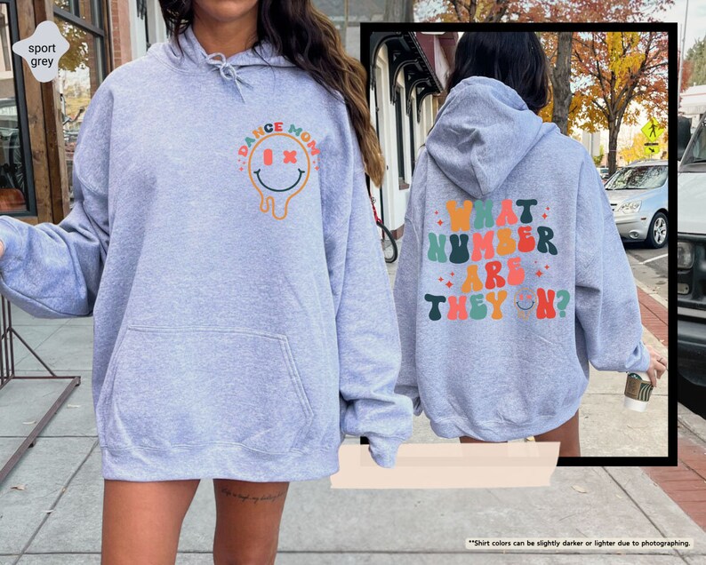 a woman in a blue hoodie is walking down the street