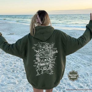 May include: A green hooded sweatshirt with a white graphic print of a flying machine with the text "Discharge" and "Air direction" on it.