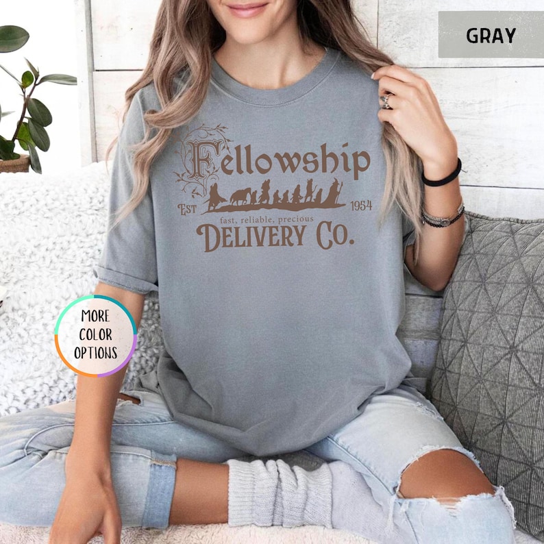 May include: Gray t-shirt with a brown graphic of the Fellowship of the Ring characters walking with the text "Fellowship Est 1954 fast, reliable, precious DELIVERY CO."