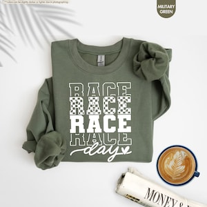 a t - shirt that says race race race day next to a cup of coffee