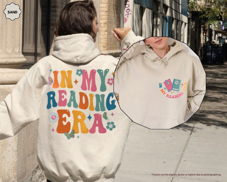 a person wearing a white hoodie with the words in my reading era on it