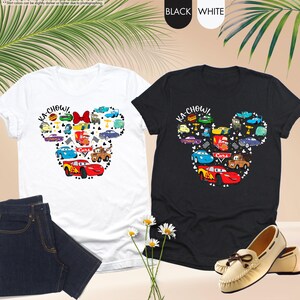 May include: Two t-shirts with a black and white design of a Mickey Mouse head made up of Cars characters. The text "KA-CHOW!" is on each shirt.