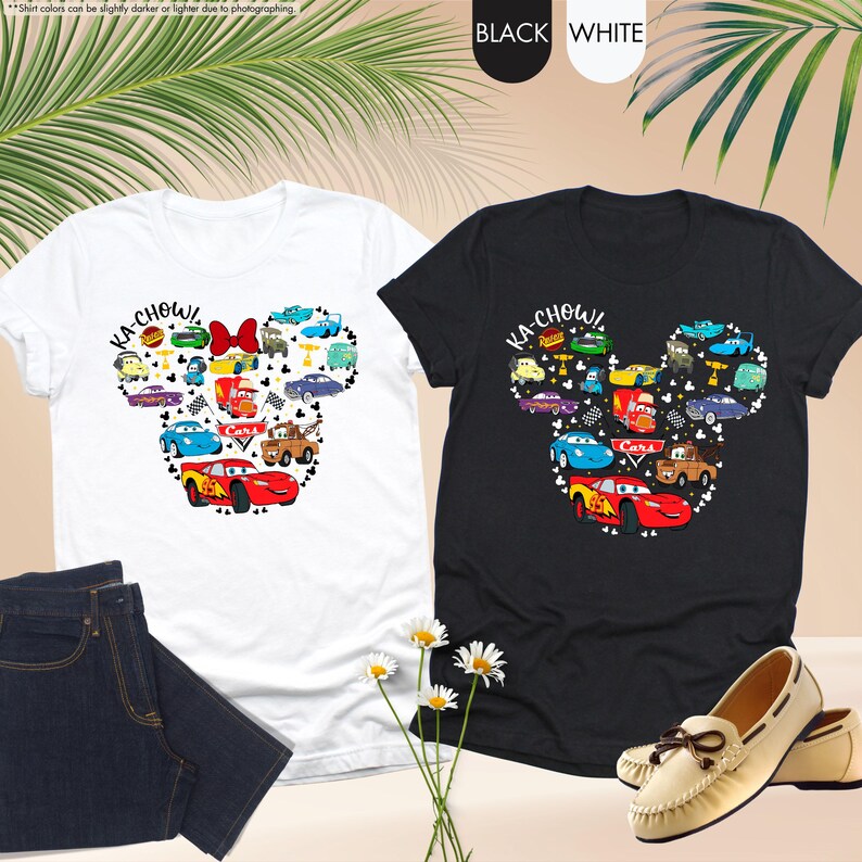 May include: Two t-shirts with a black and white design of a Mickey Mouse head made up of Cars characters. The text "KA-CHOW!" is on each shirt.
