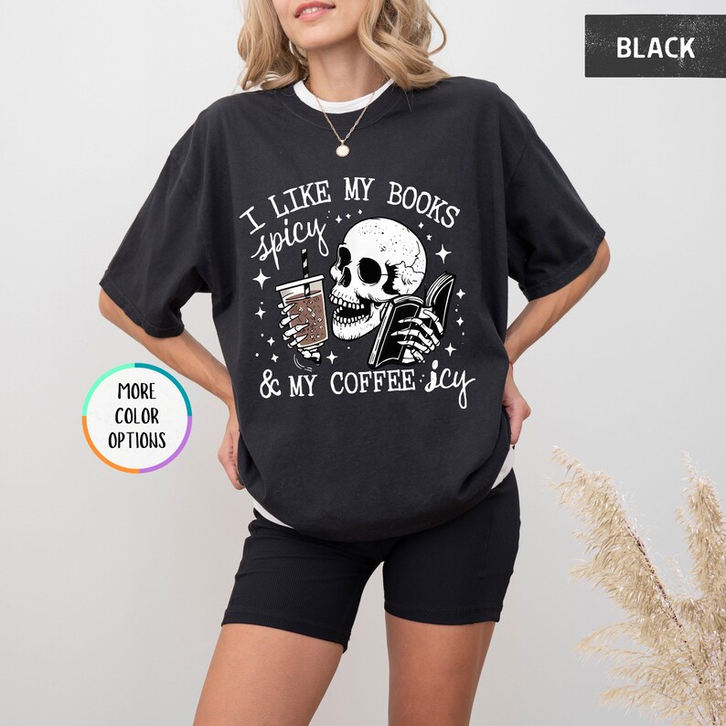 May include: Black graphic t-shirt with the text "I like my books spicy & my coffee icy." The design features a skull holding a book and a coffee cup. The shirt has a relaxed fit.