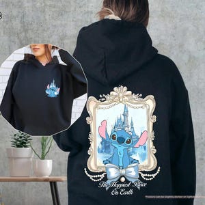 May include: Black hoodie featuring a Stitch graphic with a castle design on the back and a smaller Stitch graphic on the front. The text "The Happiest Place On Earth" is below the graphic on the back. The hoodie has a drawstring hood.