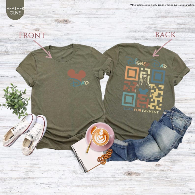 May include: A green t-shirt with a heart and the word "DAD" on the front. The back of the shirt has a retro-style QR code with the words "DISNEY" and "SCAN FOR PAYMENT".
