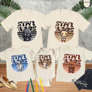 May include: Set of four beige t-shirts with a retro-style Star Wars graphic on each. The graphics feature Darth Vader, Rey, R2-D2, and Chewbacca.