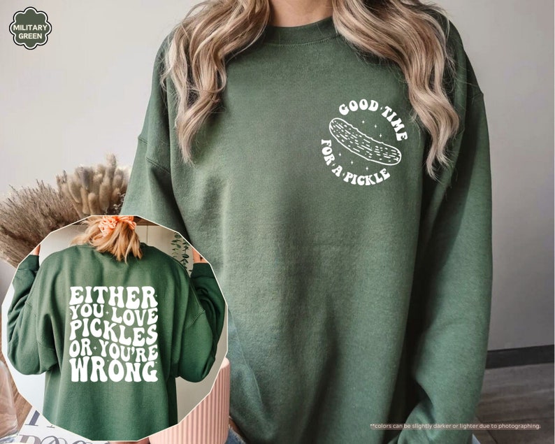 a woman wearing a green sweatshirt with a picture of a pizza on it