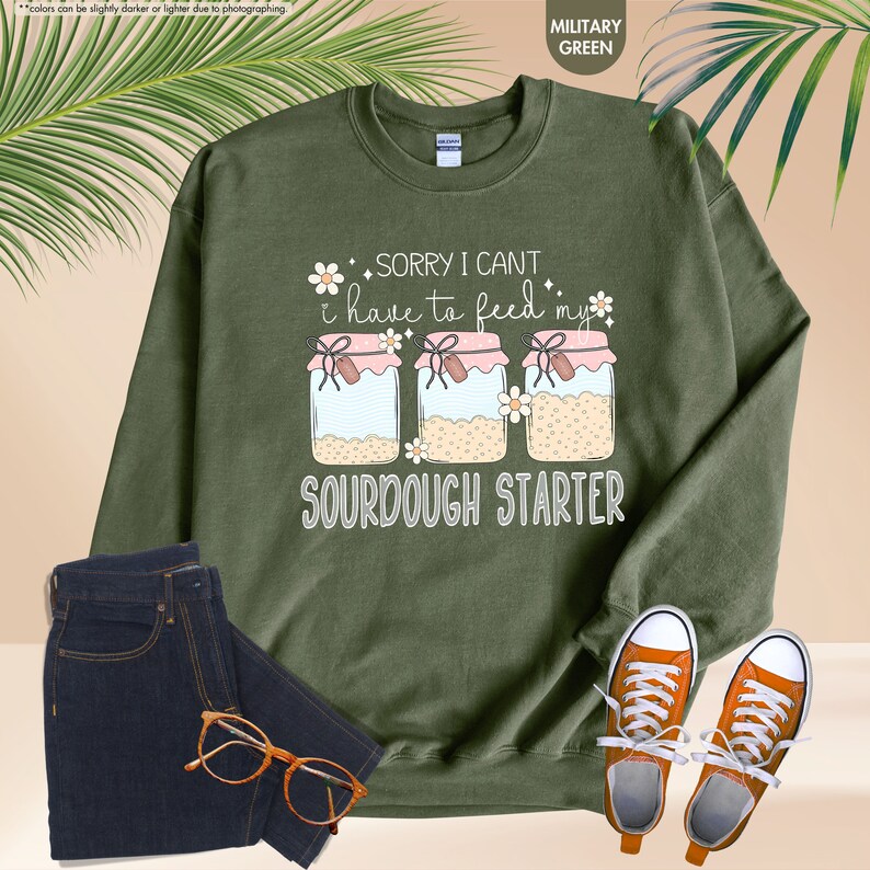 a green sweatshirt with a pair of glasses and a pair of sneakers