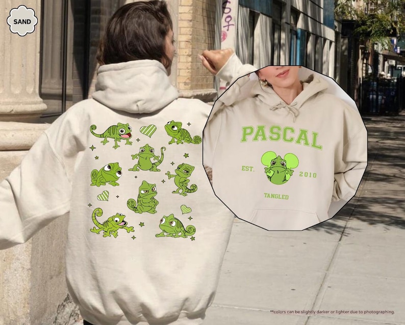 Op de afbeelding: Zandkleurige hoodie met groene kameleonafbeeldingen en het woord "PASCAL" in groen. De voorkant van de hoodie heeft een afbeelding van een kameleon met de tekst "EST. 2010 TANGLED".