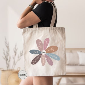 a woman carrying a tote bag with a flower on it