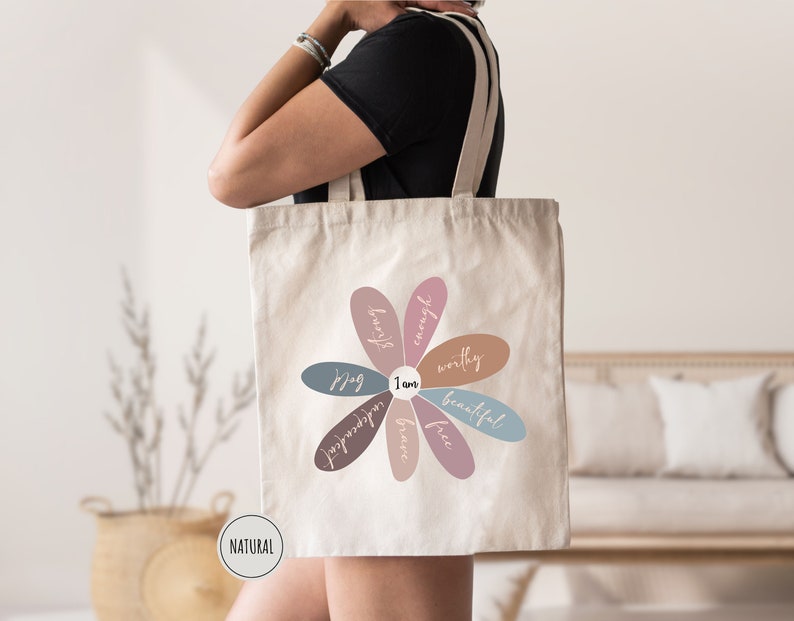 a woman carrying a tote bag with a flower on it
