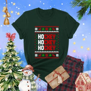 May include: Green Christmas sweater with a white, red, and green pattern. The sweater has the words "HOCKEY" repeated three times.