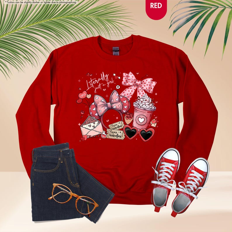May include: A red sweatshirt with a graphic featuring a bow, hearts, and the text "Literally just a girl." The image also includes a pair of blue jeans, gold-rimmed glasses, and red trainers.
