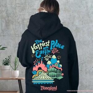 Pu&ograve; includere: Felpa con cappuccio nera con una stampa grafica colorata del castello di Disneyland e il testo "The Happiest Place on Earth" con il logo del Disneyland Resort.
