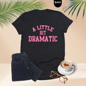 a little bit dramatic t - shirt with a cup of coffee next to it