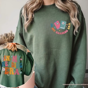 a woman wearing a green sweatshirt with a back print