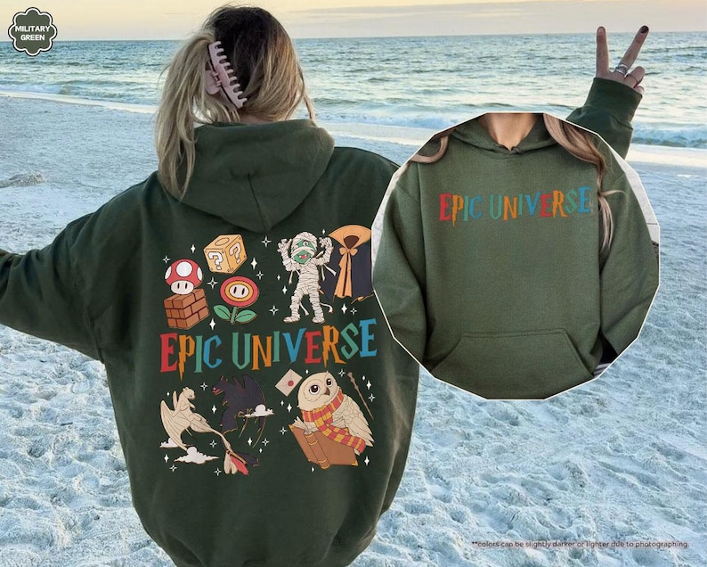 May include: A military green hoodie with the text "EPIC UNIVERSE" in colorful letters. The back of the hoodie features various cartoon graphics, including a mushroom, a cube, a mummy, and an owl reading a book.