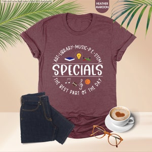 a t - shirt with the words specials on it next to a cup of coffee