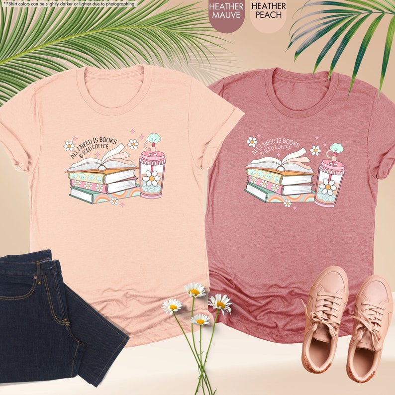 two t - shirts and a pair of jeans are next to a plant