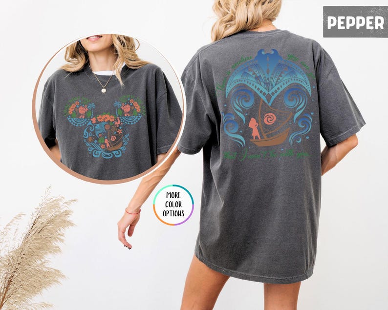 May include: A dark gray t-shirt with a colorful floral design on the front and a blue and green design on the back. The design on the back features a girl in a boat with a wave behind her. The text on the back reads "The Ocean is my happy place".