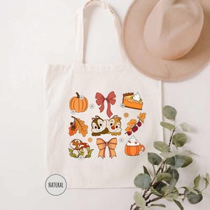 a white tote bag with a bunch of fall items on it