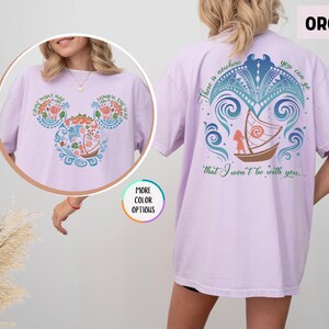 May include: Purple t-shirt with a graphic of a boat and a girl with the text "There is nowhere you can go that I won't be with you..." on the back and a graphic of Mickey Mouse ears with flowers and a boat on the front.