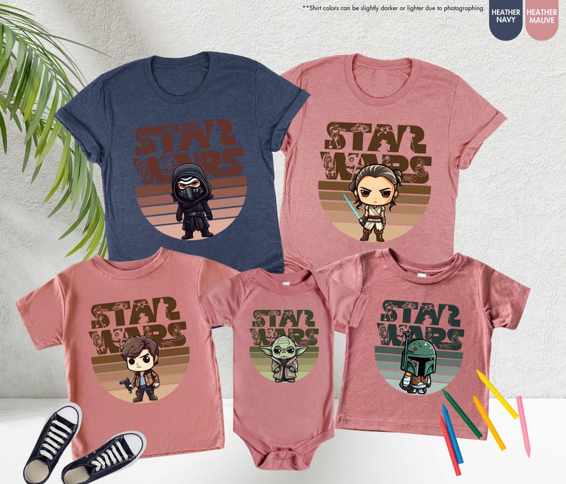 May include: Set of four Star Wars themed t-shirts in heather navy and heather mauve. The shirts feature a retro-style graphic with the text "Star Wars" and a cartoon character from the Star Wars franchise. The characters are Kylo Ren, Rey, Han Solo, and Boba Fett.