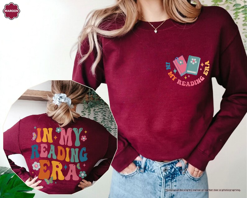 a woman wearing a red sweatshirt with a book on it