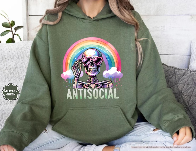 a woman sitting on a couch wearing a green hoodie