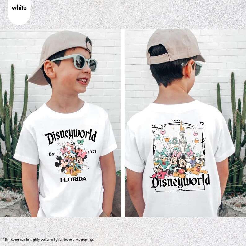 May include: White t-shirt featuring a Disneyworld design. The front of the shirt displays the text "Disneyworld Est 1971 FLORIDA" with cartoon characters. The back of the shirt has a Disney castle and characters. The shirt is worn by a person.