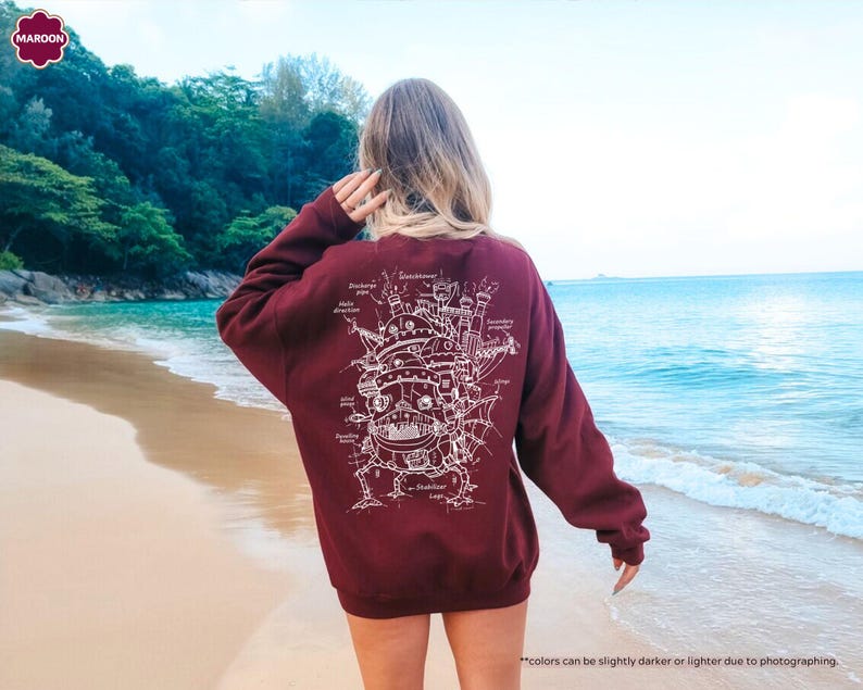 May include: A maroon sweatshirt with a white outline of a flying machine on the back. The machine is labeled with various parts and has a steampunk aesthetic.