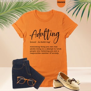 an orange shirt with a pair of glasses next to it