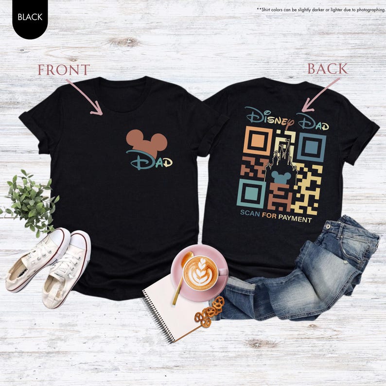 May include: Black t-shirt with a Mickey Mouse head and the word "DAD" on the front. The back of the shirt has a colorful QR code with the words "Disney Dad" and "Scan for Payment".