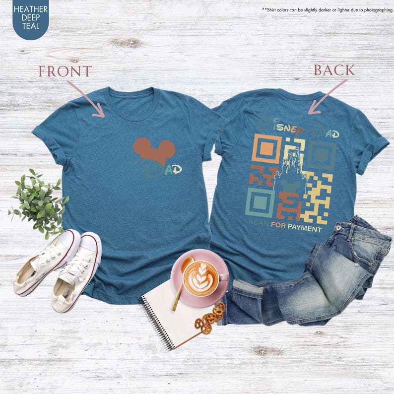 May include: A heather deep teal t-shirt with a red heart and the word "DAD" on the front. The back of the shirt has a stylized QR code with a castle and the words "SCAN FOR PAYMENT".